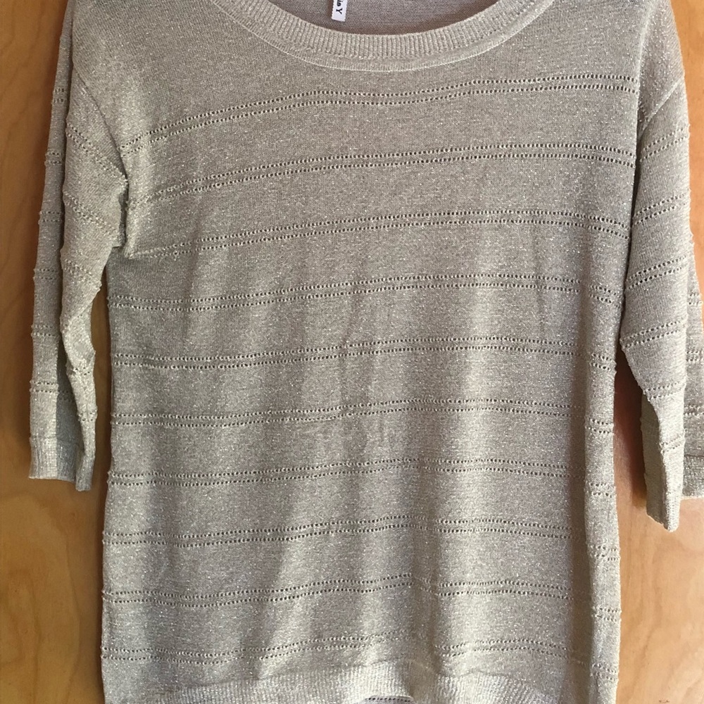 Cream sweater with gold accents.